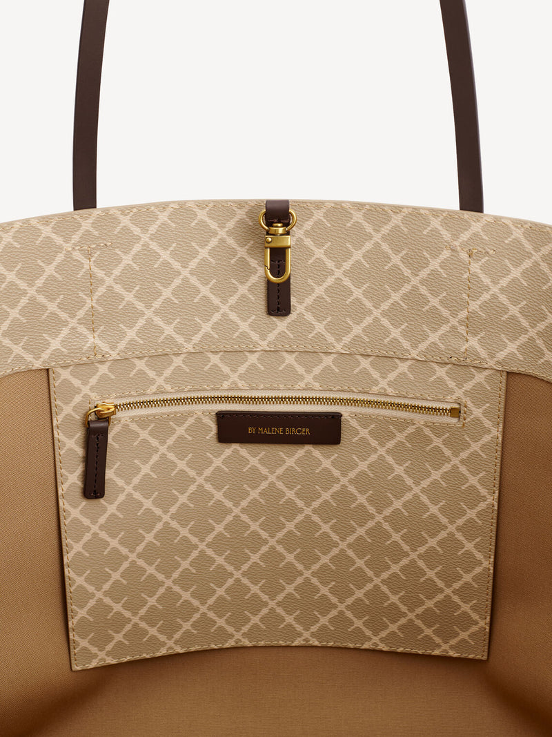 By Malene Birger Abi Tote veske i beige Signature Flower-print, med skinndetaljer og romslig design.