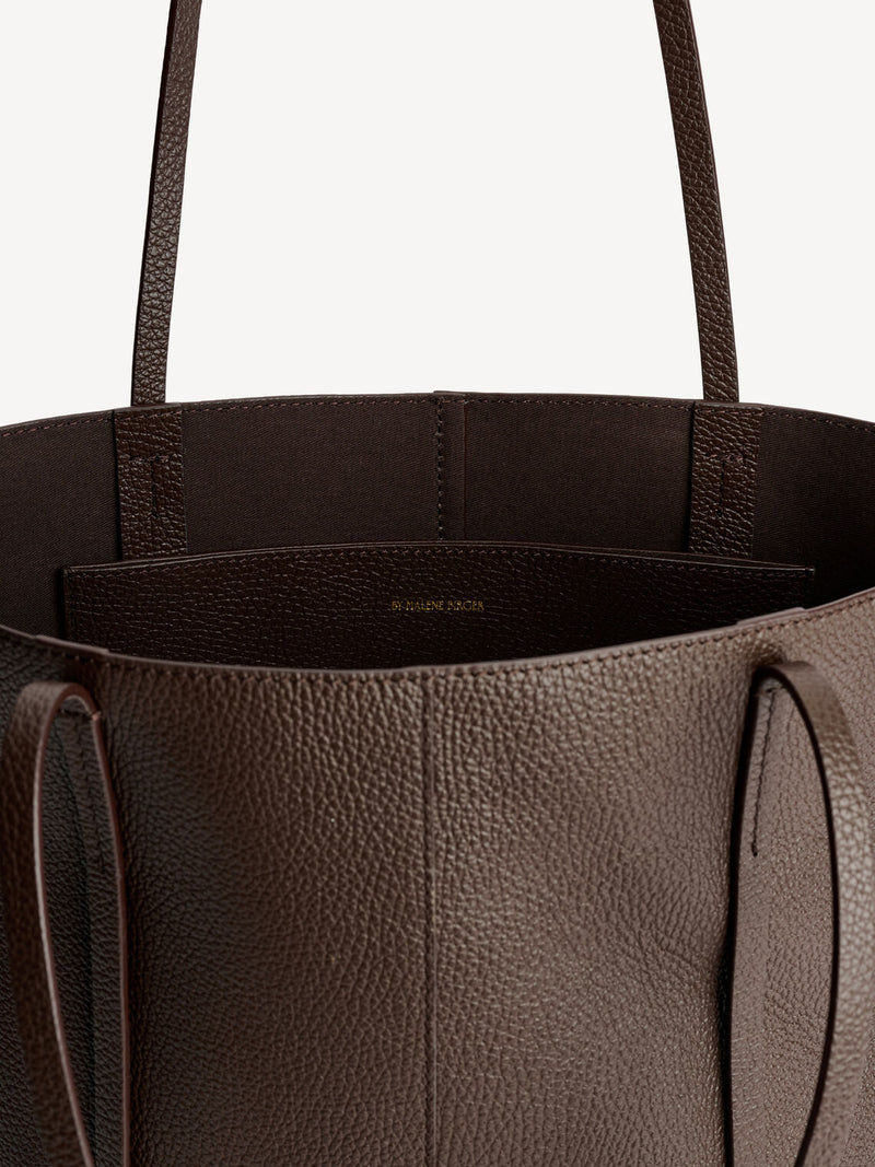By Malene Birger Abilso veske i mørkebrun, laget av kuskinn med struktur og en tote-form.