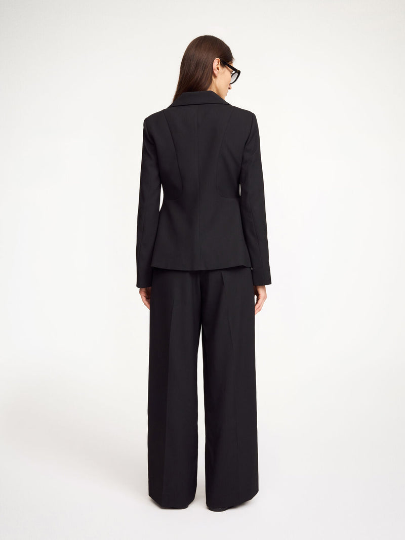 By Malene Birger Adrianna blazer i sort, med innsvinget midje for en feminin og tidløs passform, laget av resirkulert polyester, viskose og elastan.