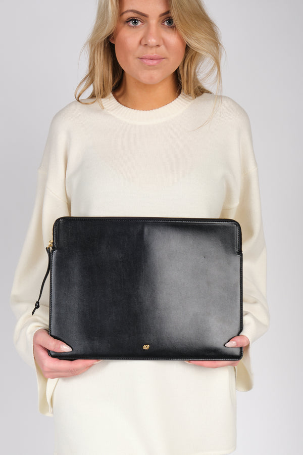 By Malene Birger Aya laptop-mappe i sort, laget av resirkulert skinn, gummi og polyuretan, med plass til en 13" MacBook.