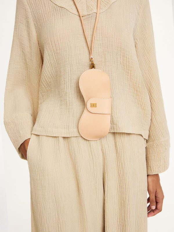 By Malene Birger Aya Sunny solbrilleetui i brun, laget av 100% ubehandlet kuskinn, med monogram-logo og avtagbar reim.