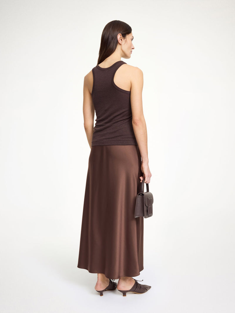 By Malene Birger Boshan skjørt i mørkebrun, med asymmetrisk snitt og elegant stil, laget av en blanding av acetat og polyester.

