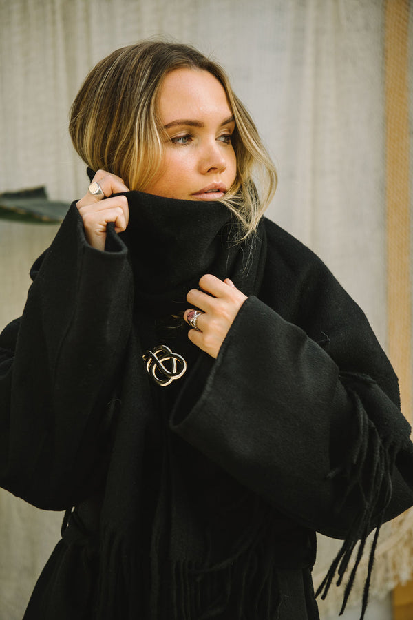 By Malene Birger Broche brosje i gullfarget sink, med myke linjer og et tidløst Swirl-motiv.