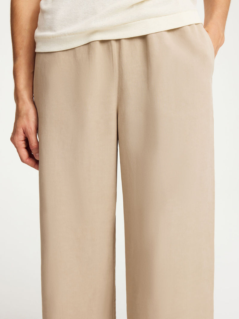 By Malene Birger Cabello bukser i beige, laget av en blanding av lyocell og lin, med strikk i livet og vide ben.