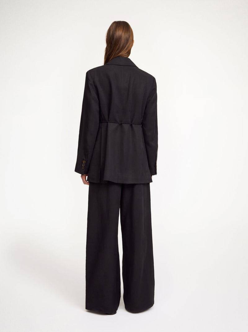 By Malene Birger Cabello bukser i sort, laget av en blanding av lyocell og lin, med strikk i livet og vide ben.