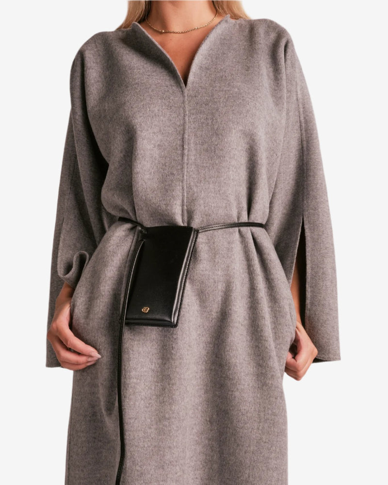 By Malene Birger Cais kjole i grått, laget av 100% ull, med en løs passform, v-utringning og splitt på ermene.