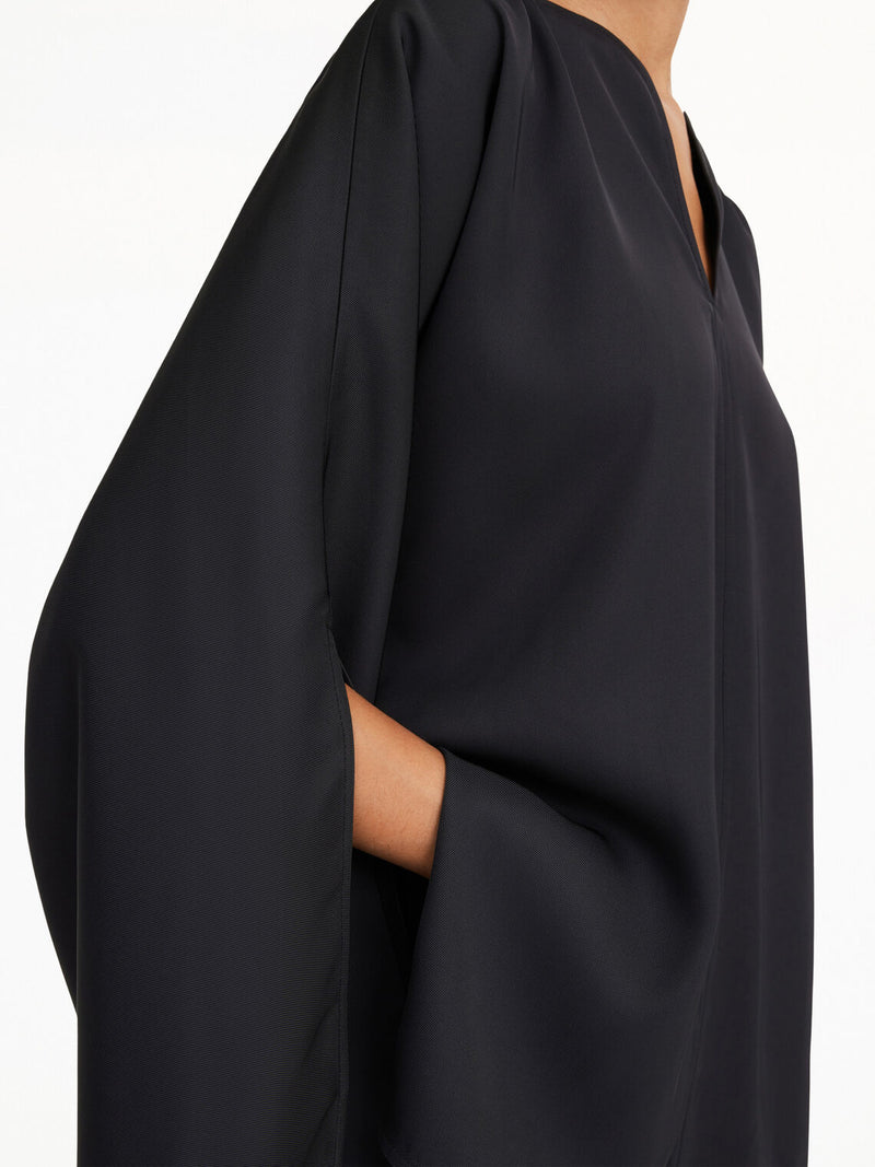 By Malene Birger Calias bluse i sort, laget av 100% acetat med splitt på ermene og v-utringning.