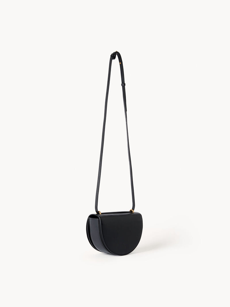 By Malene Birger Cebelle liten veske i sort kuskinn, med Swirl-motiv och justerbar axelrem.