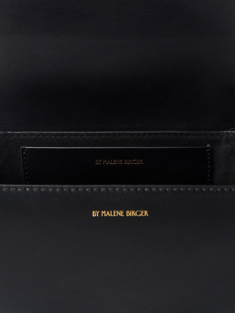 By Malene Birger Cebelle skulderveske i glatt, sort skinn, med et Scribble-motiv og justerbar skulderrem.