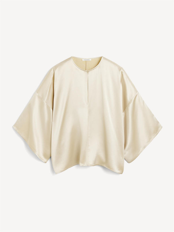 By Malene Birger Cicie bluse i kremfarget, laget av acetat og polyester, med en løs passform, albuelange ermer og v-utringning.