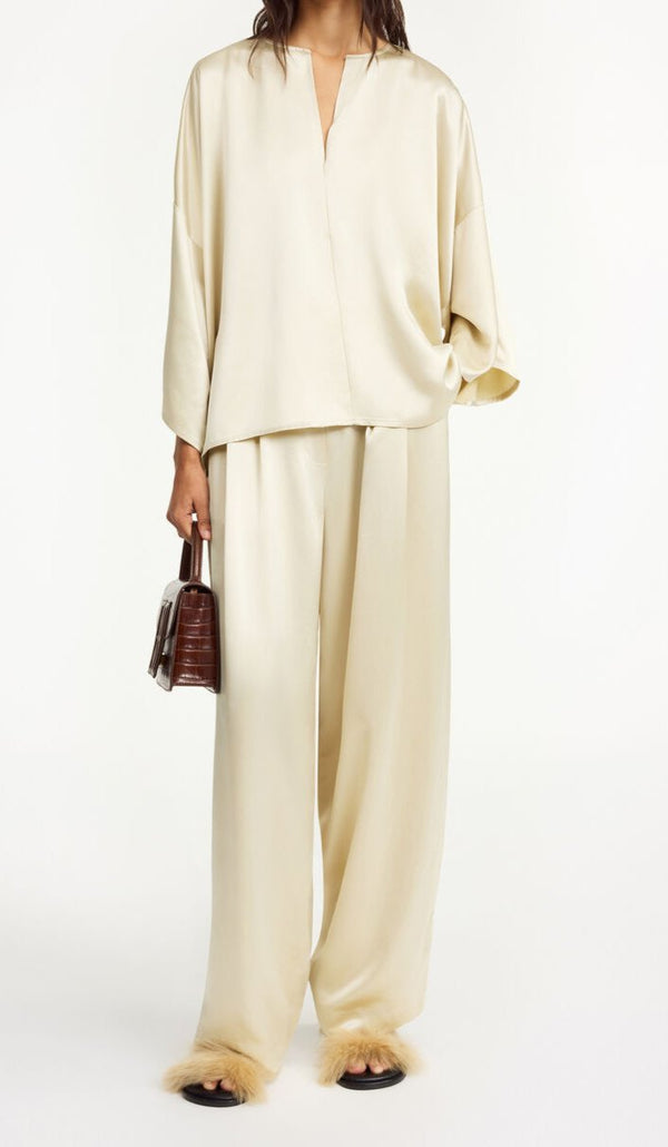 By Malene Birger Cicie bluse i kremfarget, laget av acetat og polyester, med en løs passform, albuelange ermer og v-utringning.