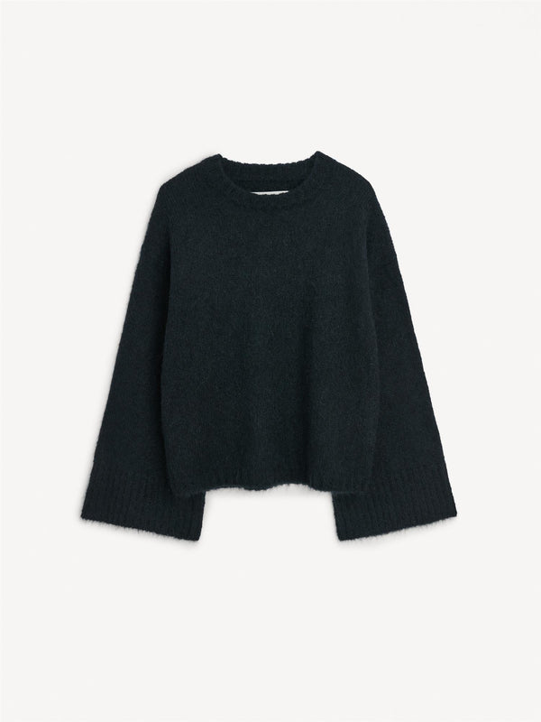 By Malene Birger Cierra genser i sort, med ribbestrikkede detaljer og trompetformede ermer, laget av en blanding av ull, mohair og polyamid.
