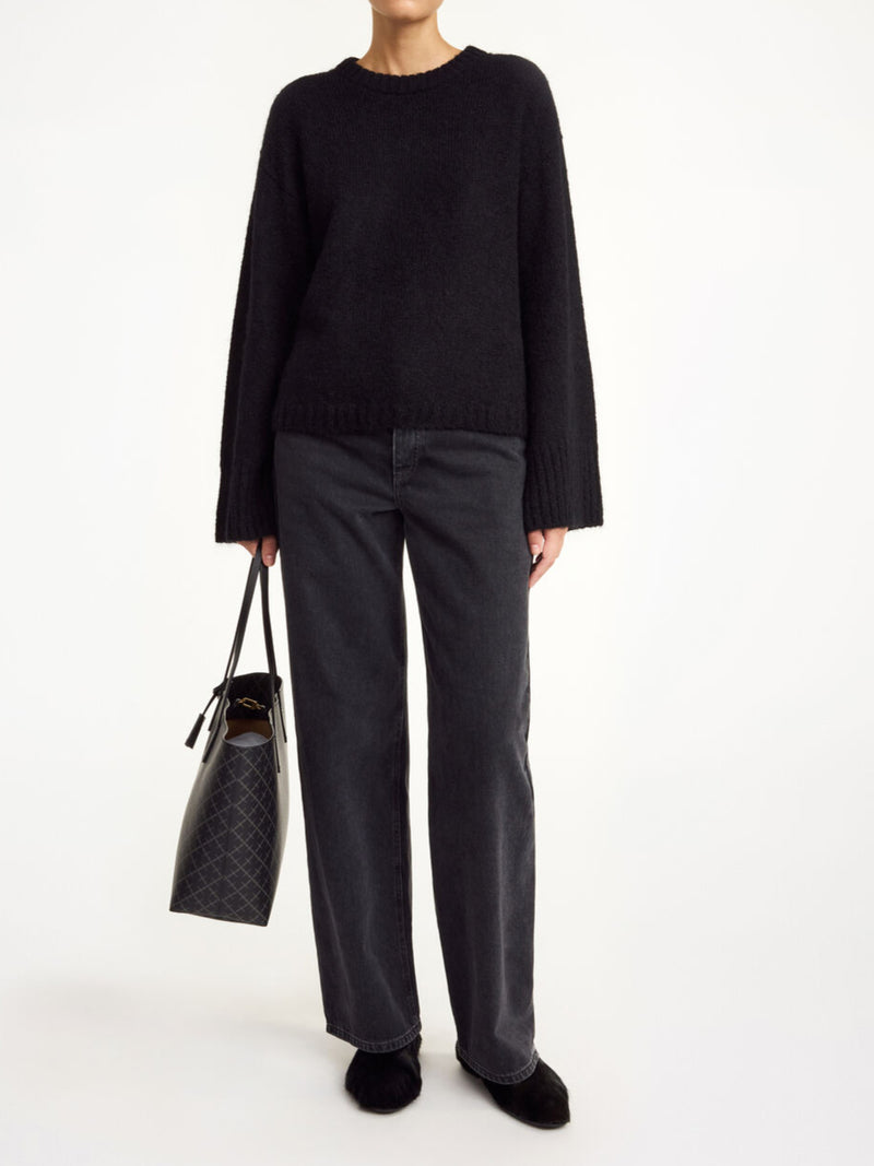 By Malene Birger Cierra genser i sort, med ribbestrikkede detaljer og trompetformede ermer, laget av en blanding av ull, mohair og polyamid.