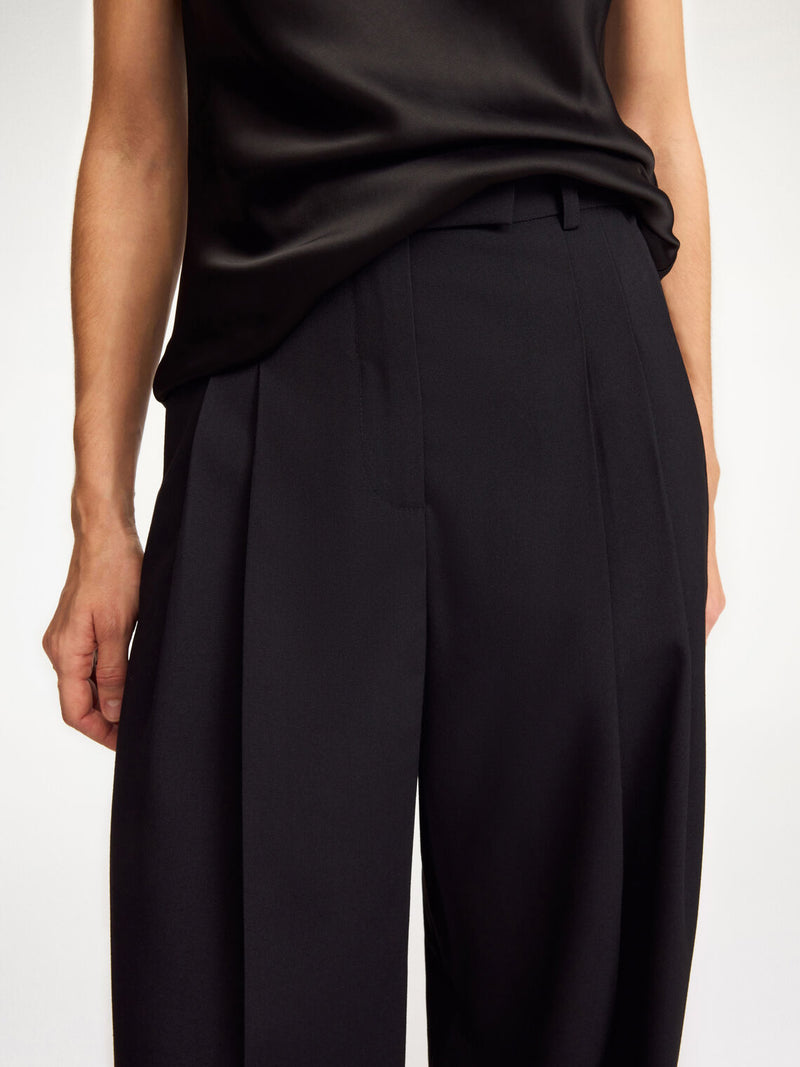By Malene Birger Cymbria bukser i sort, med en skreddersydd look, høyt liv og vide ben, laget av resirkulert polyester.