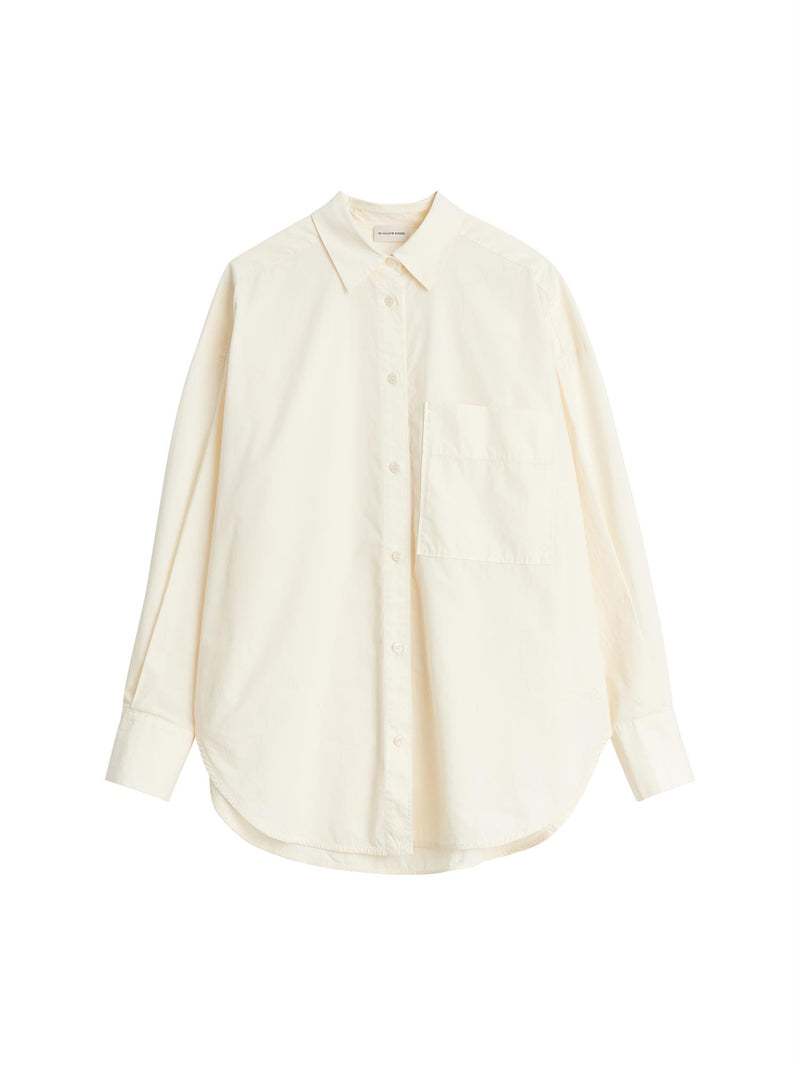 By Malene Birger Derris bomullskjorte i kremfarget, med en oversized passform og brystlomme, laget av 100% organisk bomull.