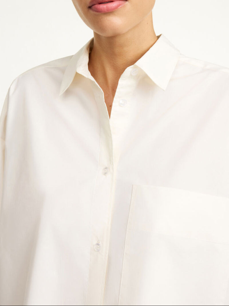 By Malene Birger Derris bomullskjorte i kremfarget, med en oversized passform og brystlomme, laget av 100% organisk bomull.