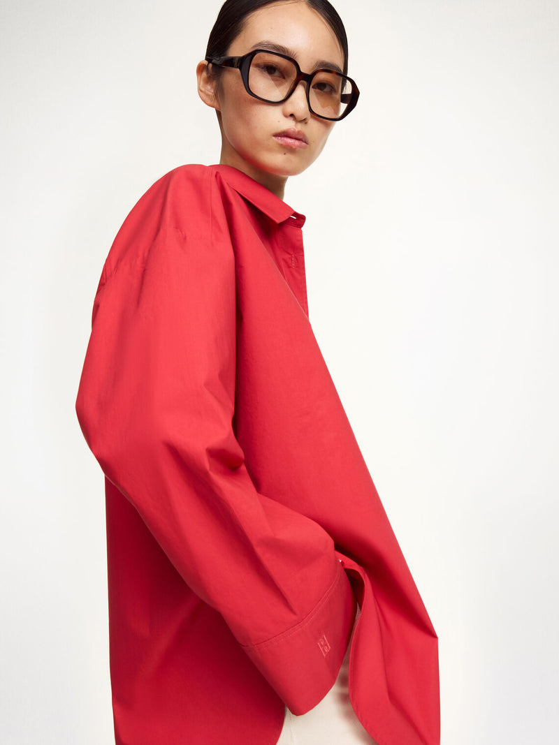By Malene Birger Derris bomullskjorte i rød, med en oversized passform og brystlomme, laget av 100% organisk bomull.