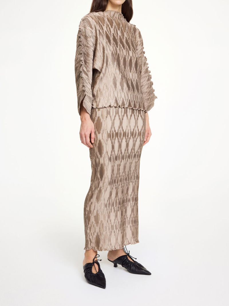 By Malene Birger Elisas skjørt i beige, laget av 100% resirkulert polyester med plissé-struktur og strikk i livet.