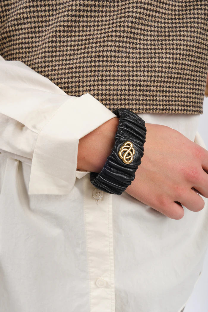 By Malene Birger Evelo armbånd i sort, laget av 100% saueskinn med et swirl-motiv.