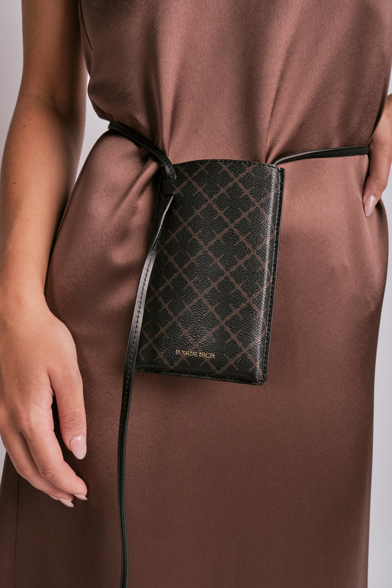 By Malene Birger Ivy Phone mobilveske i mørkebrun, laget av 100% polyvinylklorid med Signature Flower-print.