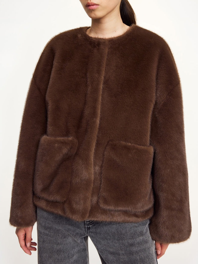 By Malene Birger Jacquie fake fur-jakke i mørkebrun, laget av 100% resirkulert polyester, med boxy passform, avtagbar krage og store lommer.