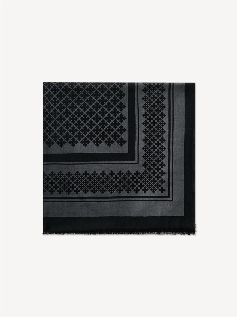 By Malene Birger Julee ullskjerf i mørk grå, med Signature Flower-print og frynser i kantene, laget av 100% ull.