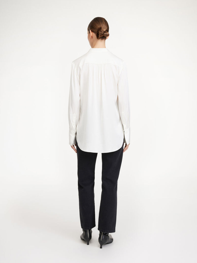 By Malene Birger Mabillon bluse i hvit, laget av en blanding av silke og elastan, med en v-utringning og knapper på mansjettene.