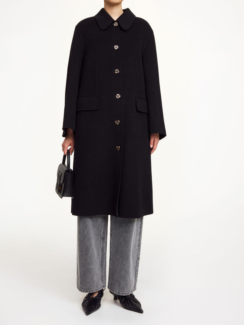 By Malene Birger Maelle kåpe i sort, med en rett passform, buet krage og laget av 100% ull.