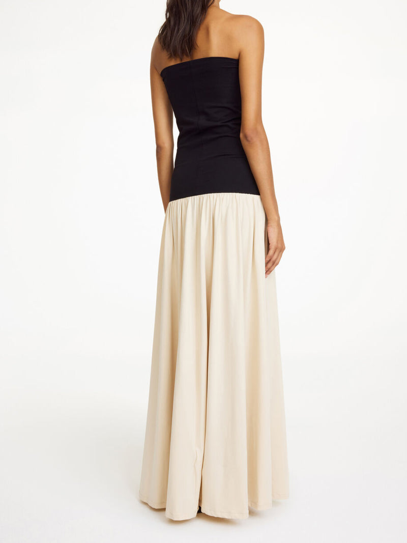 By Malene Birger Marciella kjole i sort og kremfarget, med en nedbrettbar tubetopp og voluminøst skjørt, laget av organisk bomull og elastan.