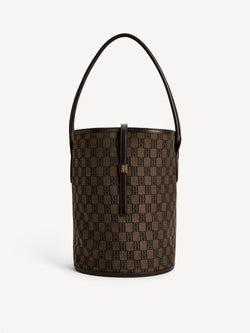 By Malene Birger Maryllon veske i brun, med bøtteform, laget av resirkulert bomull og polyester, og et gullfarget monogram-emblem i front.