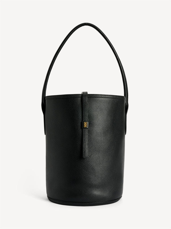 By Malene Birger Maryllon veske i sort skinn, med bøtteform og gullfarget monogram-emblem i front.