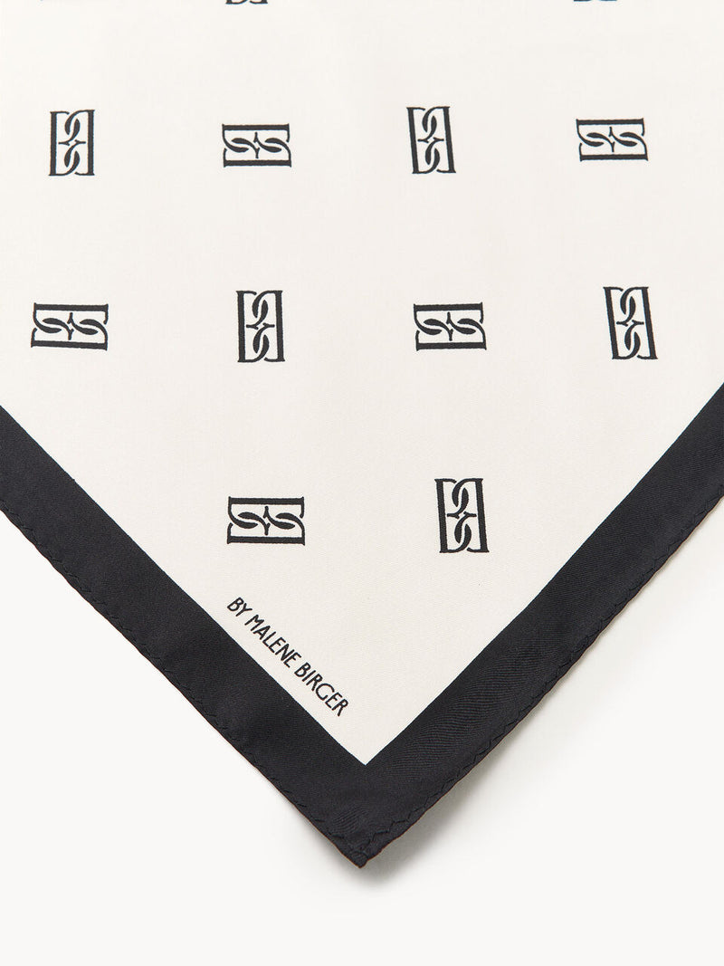 By Malene Birger Monnas skjerf i hvit silke, med BB monogram-mønster.