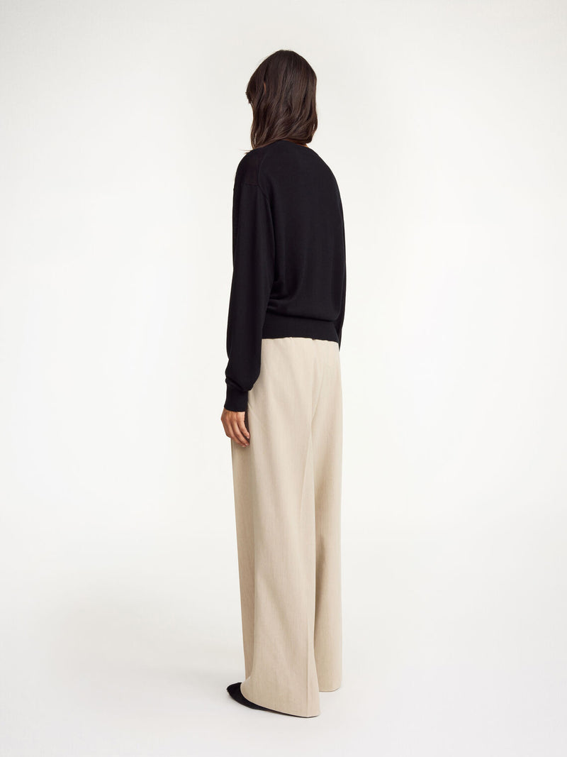 By Malene Birger Montie cardigan i sort, med ribbestrikkede kanter, rund hals og laget av en blanding av ull, silke og lyocell.