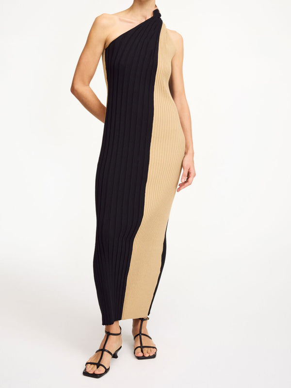 By Malene Birger Noto kjole i sort og beige, med asymmetrisk design over skuldrene og snurret avslutning.
