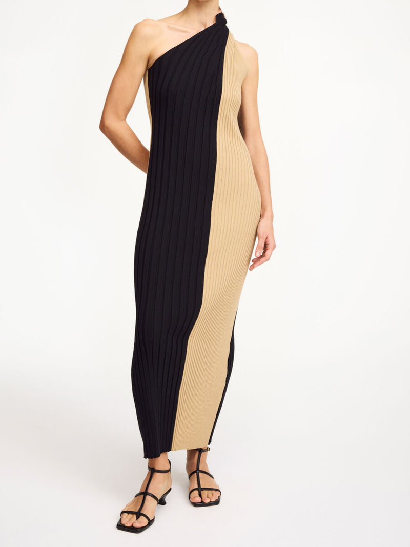By Malene Birger Noto kjole i sort og beige, med asymmetrisk design over skuldrene og snurret avslutning.
