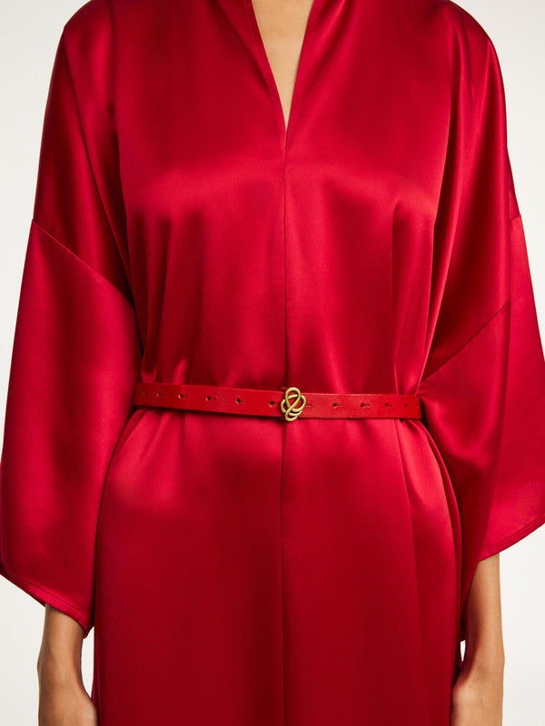 By Malene Birger Ouma belte i rød kuskinn, med en swirl-emblem beltespenne i gullfarge.