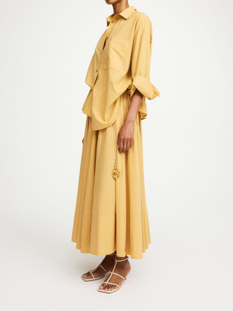 By Malene Birger Pheo maxi-skjørt i mørk gul, laget av 100% organisk bomull, med strikk i livet og en voluminøs A-form.