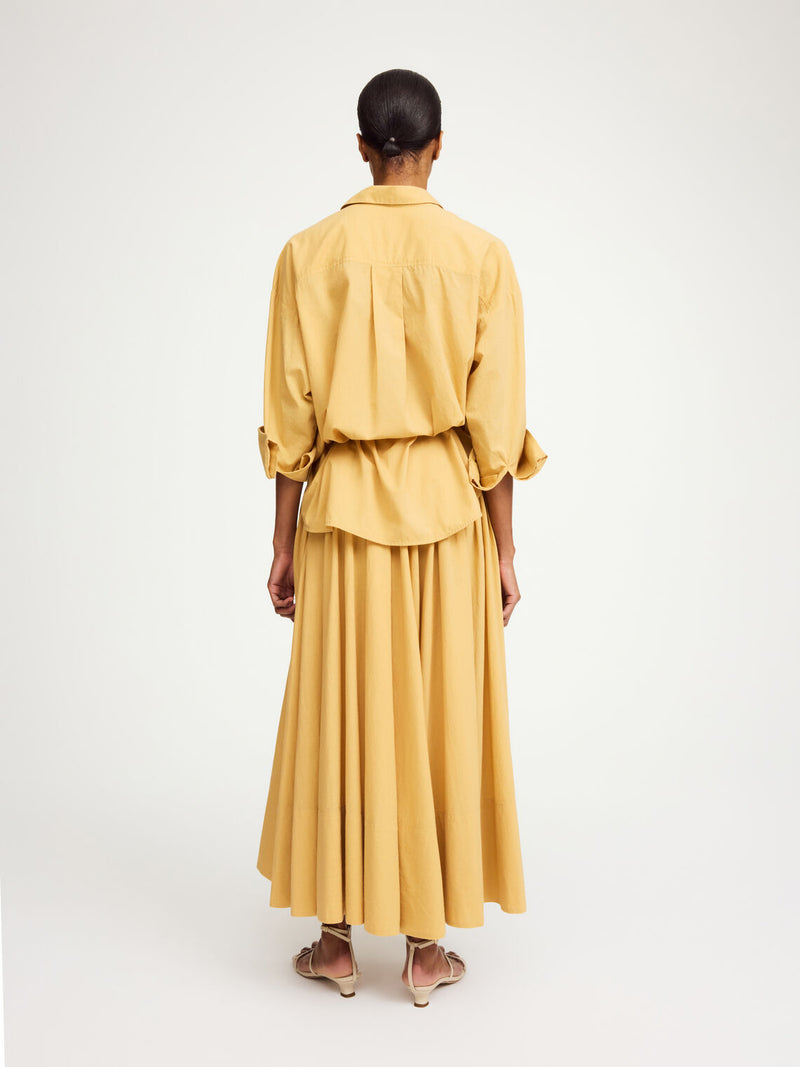 By Malene Birger Pheo maxi-skjørt i mørk gul, laget av 100% organisk bomull, med strikk i livet og en voluminøs A-form.
