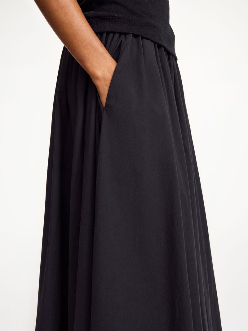 By Malene Birger Pheo maxi-skjørt i sort, laget av 100% organisk bomull, med strikk i livet og en voluminøs A-form.