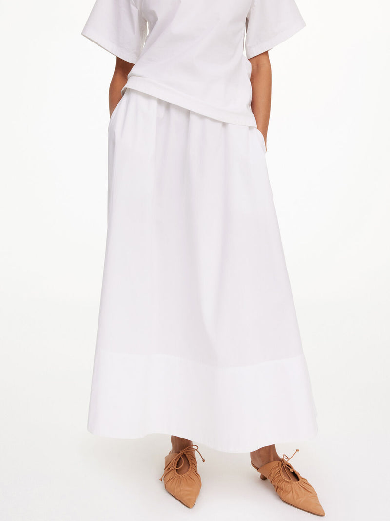 By Malene Birger Pheobes bomullsskjørt i hvit, med strikk i midjen og en A-formet silhuett, laget av 100% organisk bomull.