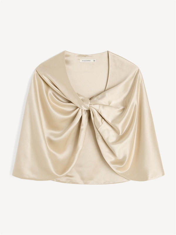 By Malene Birger Pinlos cape i kremfarget sateng, laget av en bærekraftig blanding av acetat og polyester, med knutedetaljer i front.

