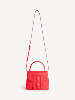 By Malene Birger Ramil veske i strukturert rød skinn, med monogram-motiv i front og justerbar skulderreim.