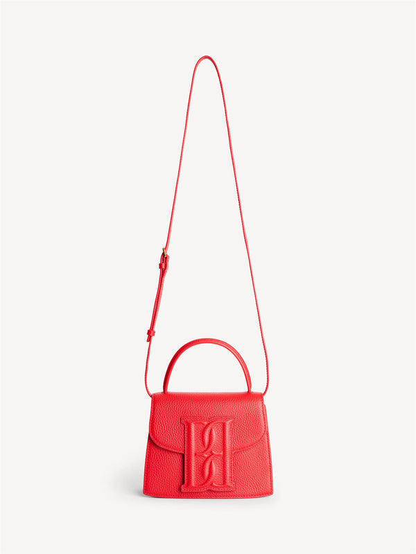 By Malene Birger Ramil veske i strukturert rød skinn, med monogram-motiv i front og justerbar skulderreim.