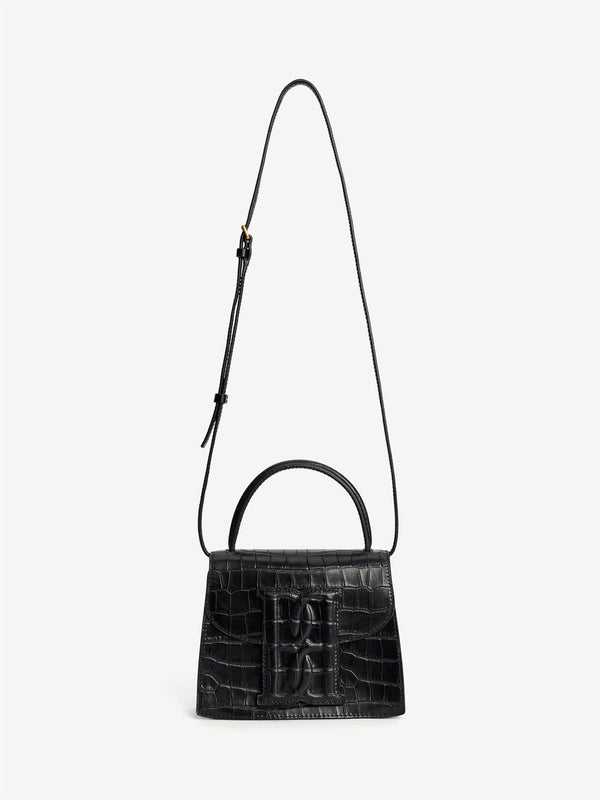 By Malene Birger Ramil veske i sort kalveskinn med krokomønster, monogram-motiv i front og justerbar skulderreim.