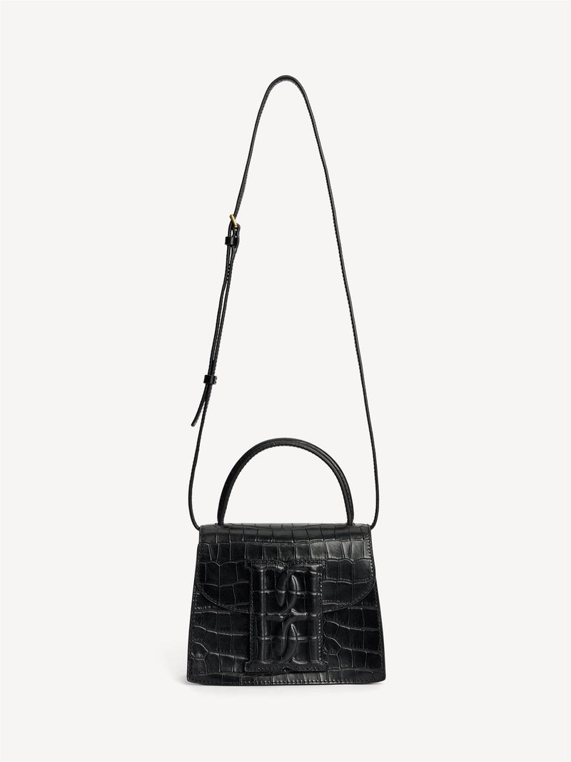 By Malene Birger Ramil veske i sort kalveskinn med krokomønster, monogram-motiv i front og justerbar skulderreim.