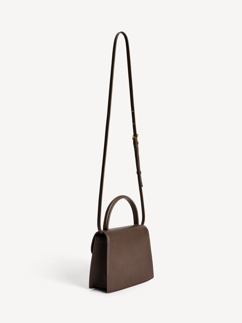 By Malene Birger Ramil veske i strukturert mørkebrun skinn, med monogram-motiv i front og justerbar skulderreim.