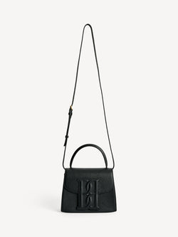 By Malene Birger Ramil veske i strukturert sort skinn, med monogram-motiv i front og justerbar skulderreim.