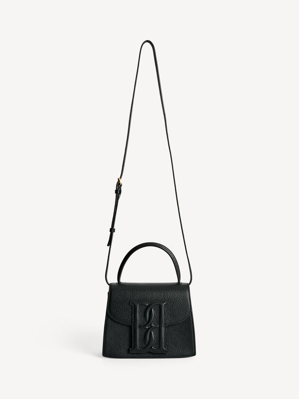 By Malene Birger Ramil veske i strukturert sort skinn, med monogram-motiv i front og justerbar skulderreim.