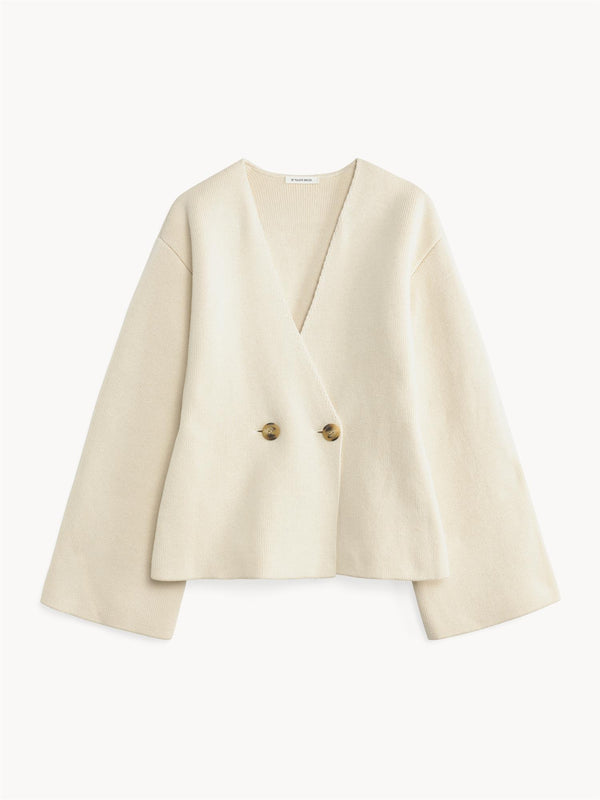 By Malene Birger Tinley cardigan i hvit, med et dobbeltspent uttrykk og feminine trompetarmer, laget av ull, bomull og elastan.