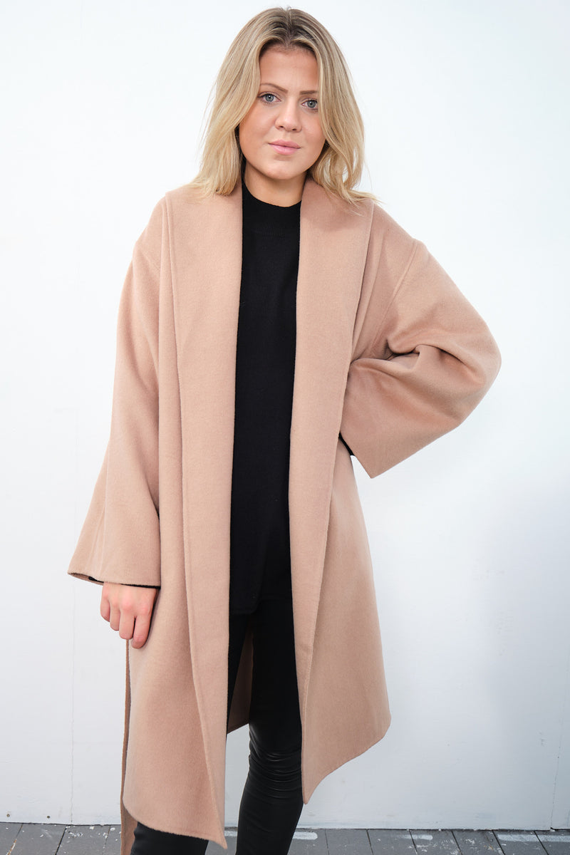 By Malene Birger Trullas kåpe i brun, med en sjal-lignende krage og en rett passform, laget av 100% ull.